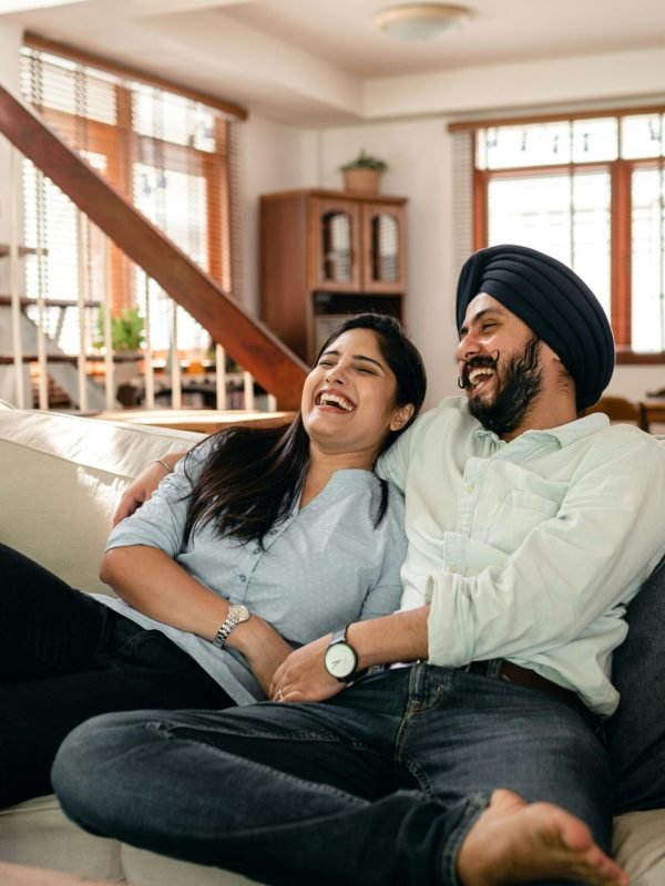 Smiling couple admires their newly designed living room, showcasing the expertise of Happy Clients Interior Design.